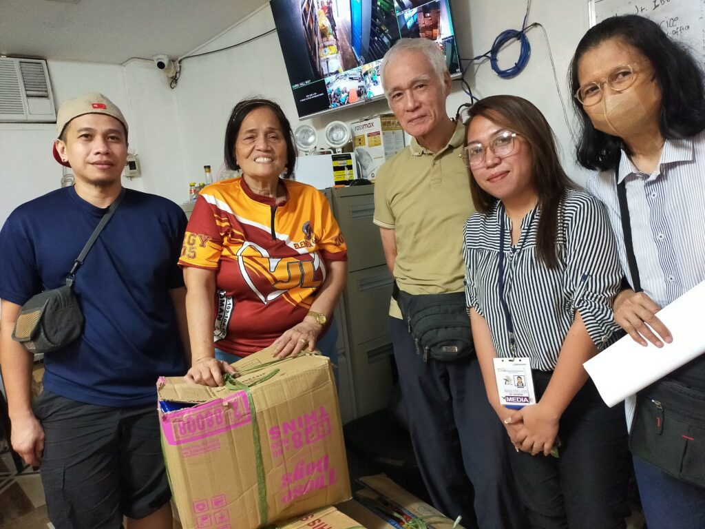 バランガイ議長に食料品を受け渡しているアクセス現地スタッフ